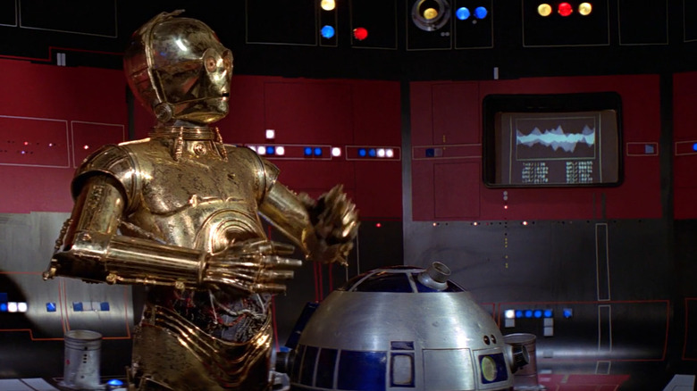 C-3PO e R2-D2 em pé em uma sala de controle na Estrela da Morte em Guerra nas Estrelas: Uma Nova Esperança