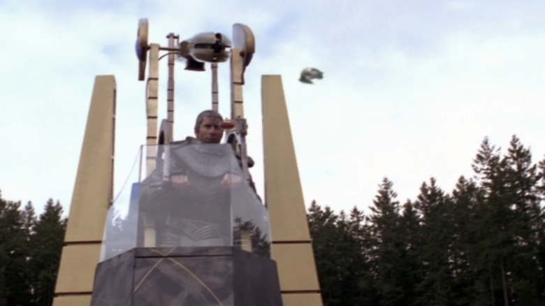 A Jaffa mans a weapon tower with a spaceship visible in the background in Stargate SG-1