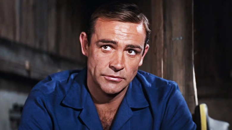 Sean Connery's James Bond looks up while sitting in a boat house in Thunderball
