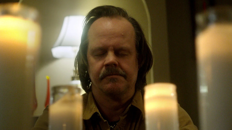 Jacob Lewis sits on a candle altar in 