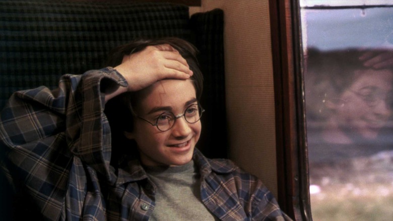 Harry showing off his scar and smiling in Harry Potter and the Sorcerer's Stone