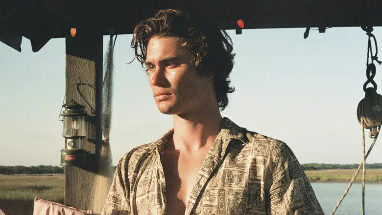 Chase Stokes luciendo de mal humor y melancólico como John B en el drama de Netflix, Outer Banks.