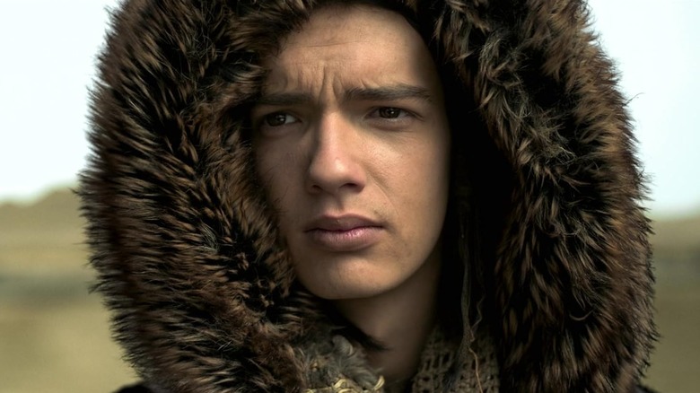 Kody Smit-McPhee as Keda staring while wearing a fluffy hood in Alpha