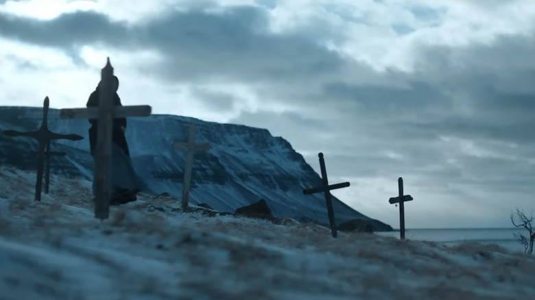 Odessa Young, while Eva walks between the graves in the lane