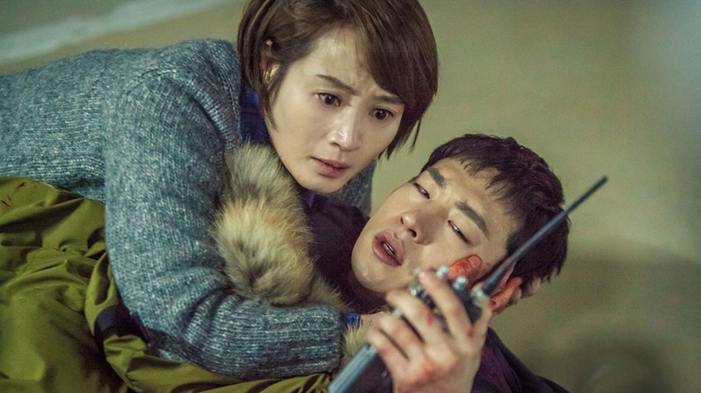 Cha Soo-hyun (Kim Hye-soo) lays on Park Hae-young (Lee Je-hoon) as he speaks in a walkie-talkie in Signal (2016)