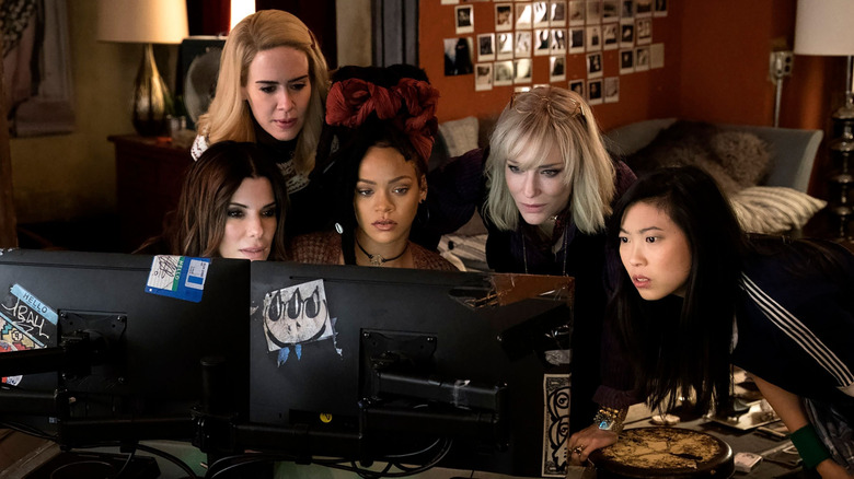 Sandra Bullock as Debbie, Sarah Paulson as Tammy, Rihanna as Nine Ball, Cate Blanchett as Lou, and Awkwafina as Constance all looking at computer monitors in Ocean's 8