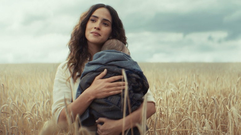 Bix holding her and Cassian's child in a field on Mina-Rau in Andor