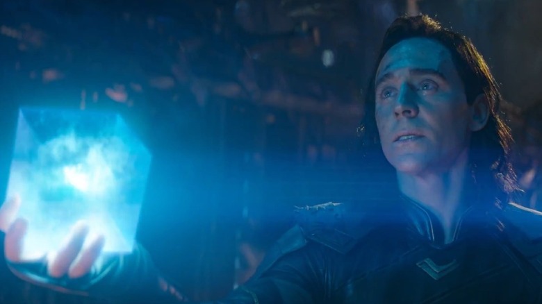 Tom Hiddleston as Loki holding up the Tesseract in Avengers: Infinity War