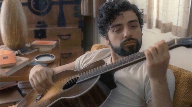 Oscar Isaac ties on his Davistor guitar sodar inside Llewyn Davis