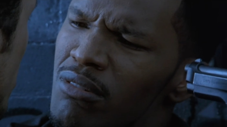 Jamie Foxx sebagai Alvin dengan pistol ditekan ke kepalanya dengan umpan