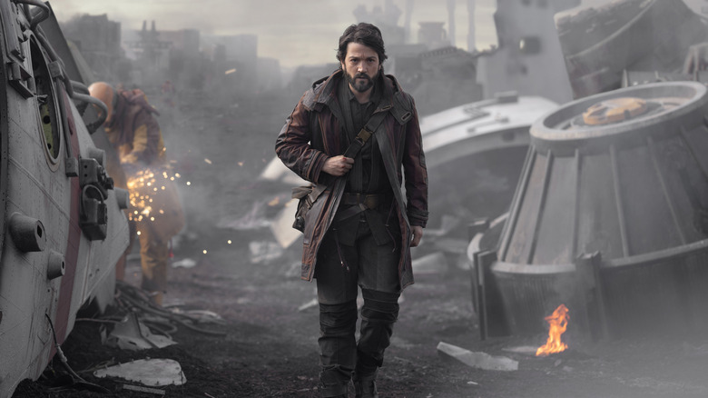 Cassian walking through a scrapyard on Ferrix in Andor