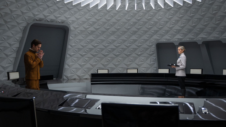 Kyle Soller as Syril Karn and Denise Gough as Dedra Meero standing in an Imperial briefing room in Andor season 2
