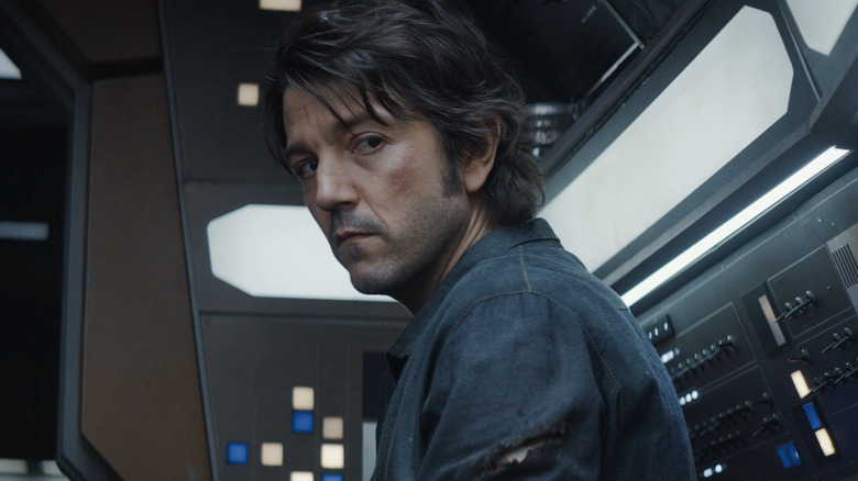 Cassian Andor stands inside a spaceship looking pensive in Andor