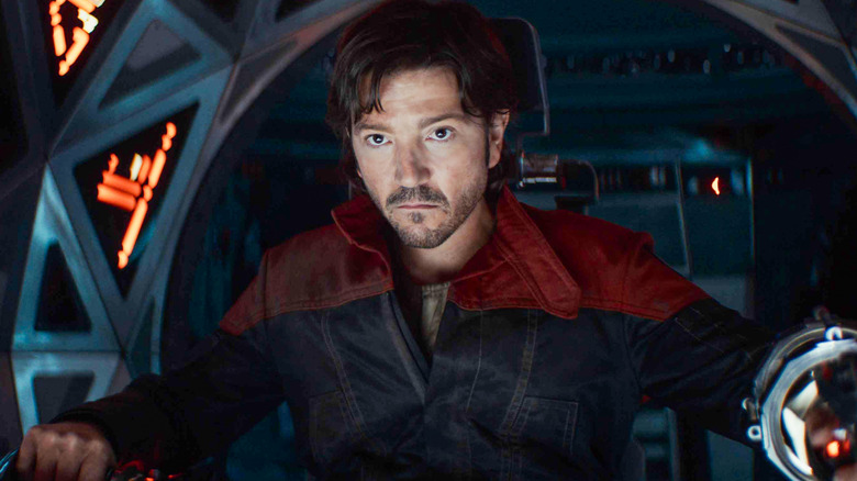 Cassian piloting a ship with a concerned look on his face in Andor