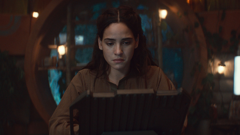 Bix looks sadly at a computer screen in her home on Yavin in Andor season 2