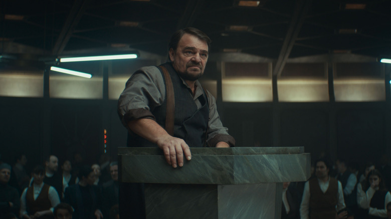 A character stands at a lectern and addresses his countrymen in Andor season 2