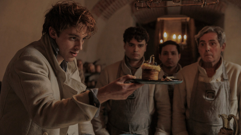 Careme holds a dessert to his kitchen staff in Careme