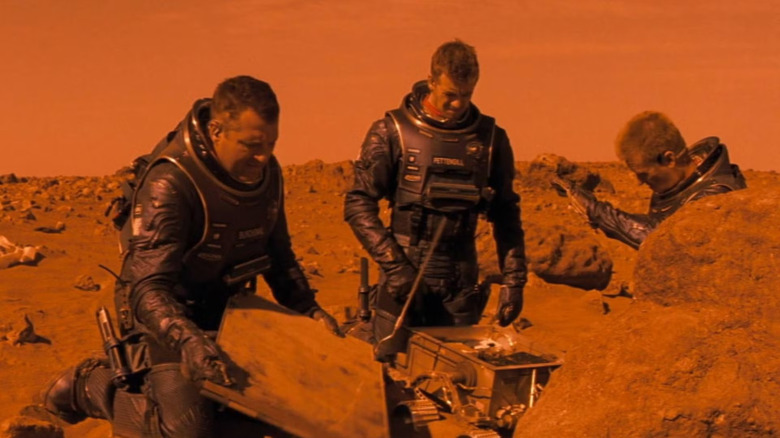 Dr. Burchenal, Dr. Pettengill, and Robby Gallagher all in space suits on Mars in Red Planet