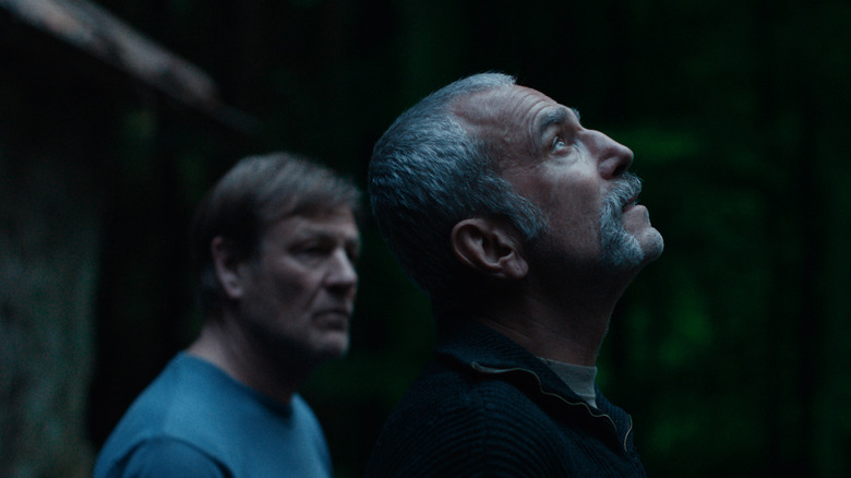 Daniel Day-Lewis as Ray looking up at the skies as Sean Bean as Jem stands behind him in Anemone