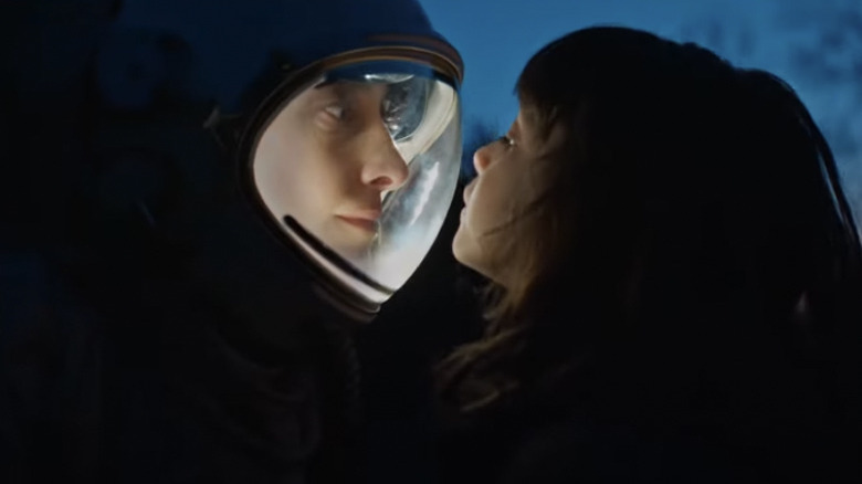 A child face to face with a person wearing a helmet