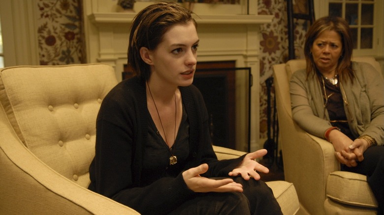 Kym looking angry next to Carol in a living room in Rachel Getting Married