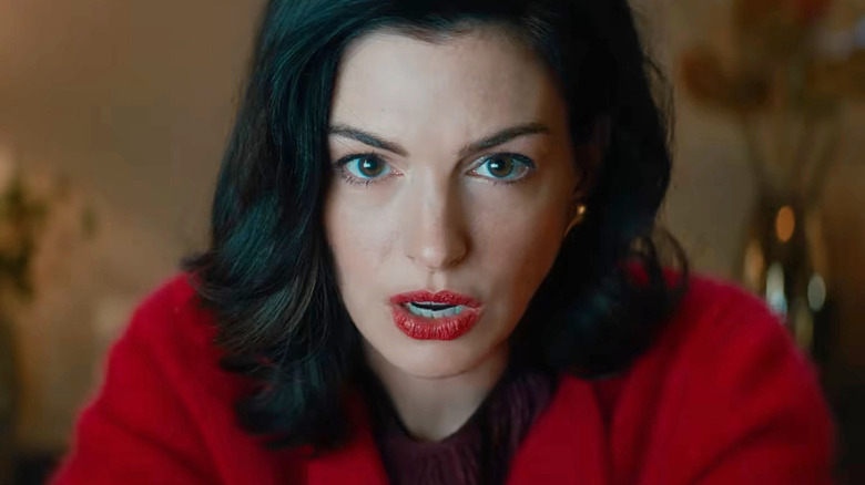 Anne Hathaway as Verity Crawford sitting at her desk in Verity