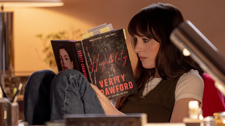 Dakota Johnson as Lowen reading Hospitality at her desk in Verity