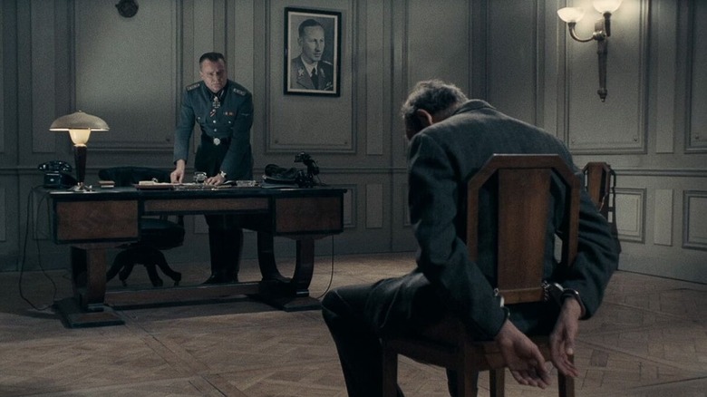 An interrogation officer (Jacques Marbeuf) ties up and interrogates Félix Lepercq (Paul Crauchet) in Army of Shadows