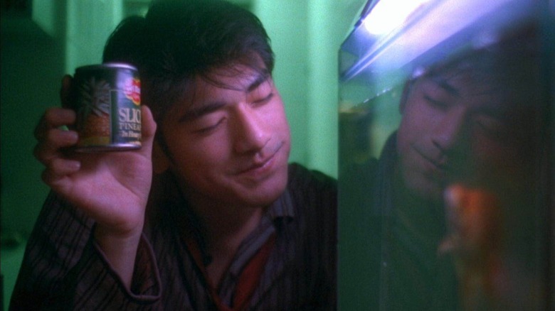 He Zhi Wu (Takeshi Kaneshiro) offers pineapples to a fish in Chungking Express