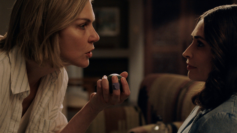 Rhea Seehorn's Carol Sturka  leans in as she talks to Karolina Wydra's in Pluribus