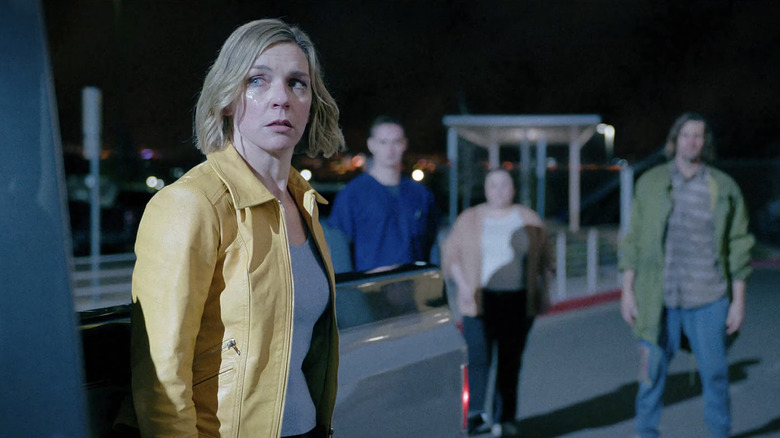 Rhea Seehorn's Carol Sturka stands in a street surrounded by members of the hive mind in Pluribus