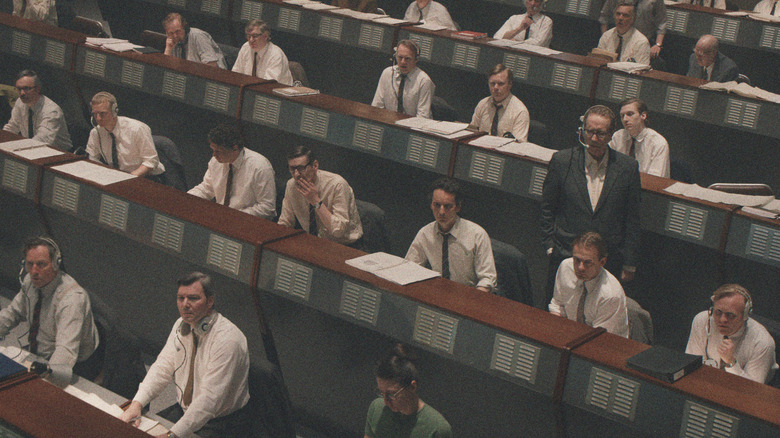 Various employees in white suits and ties at work in Star City