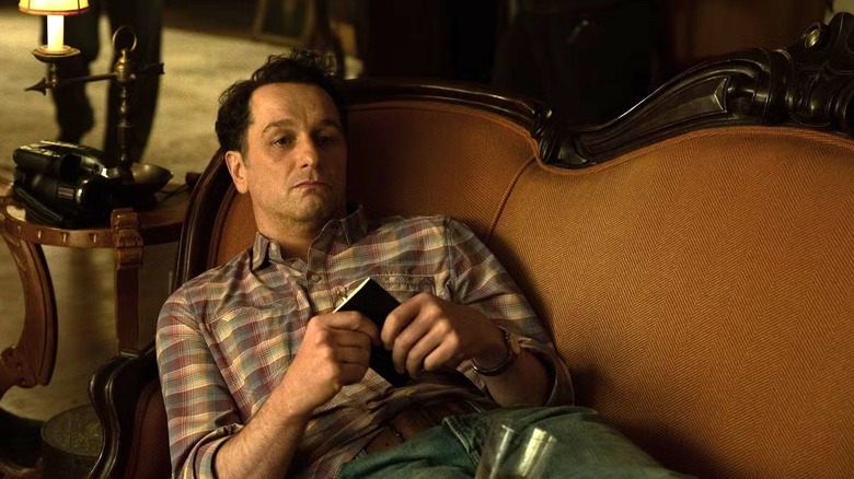 Tom Loftis (Matthew Rhys) sitting on a couch in Widow's Bay