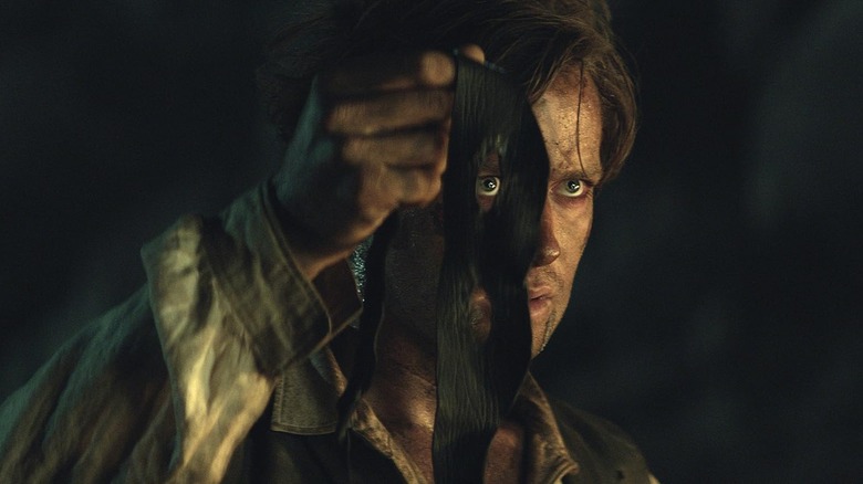 John Reid holding his face mask in The Lone Ranger (2013)