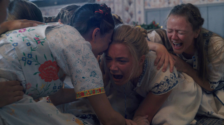 Dani manically cries with other women