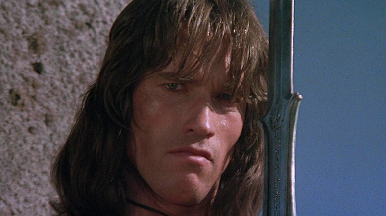 Arnold Schwarzenegger como Conan con una espada en Conan el Bárbaro