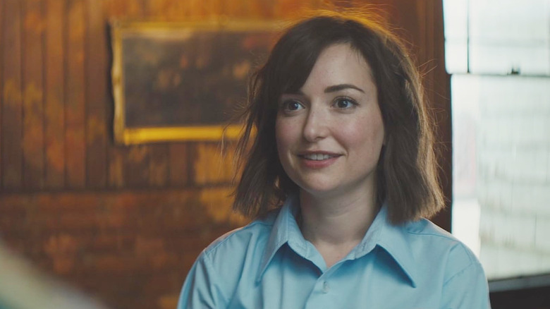 Milana Vayntrub as Cecily Moore smiling in Werewolves Within