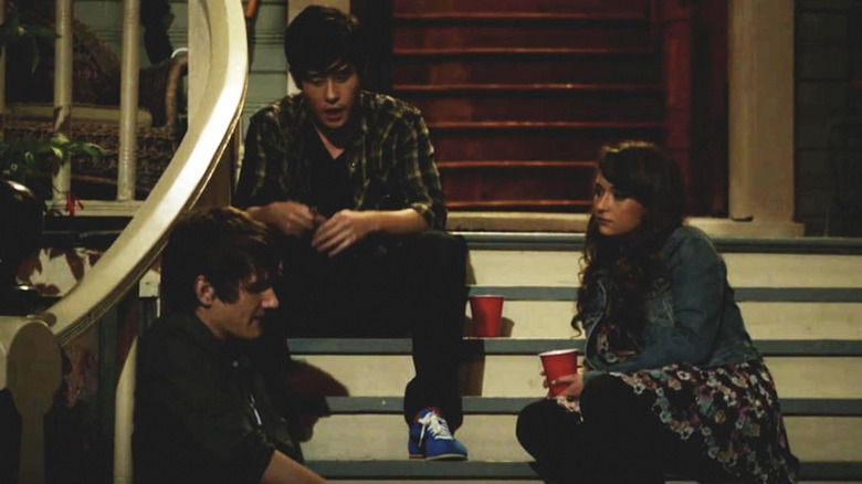 Bo Burnham's Zach Stone, Cameron Palatas' Andy Stone, and Milana Vayntrub's Felcia sitting on some stairs on Zach Stone Is Gonna Be Famous