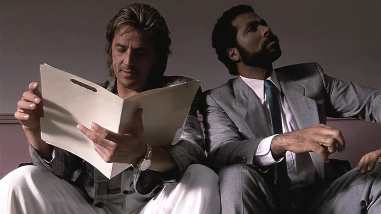 Don Johnson as Sonny Crockett and Philip Michael Thomas as Ricardo Tubbs sit next to each other in Miami Vice