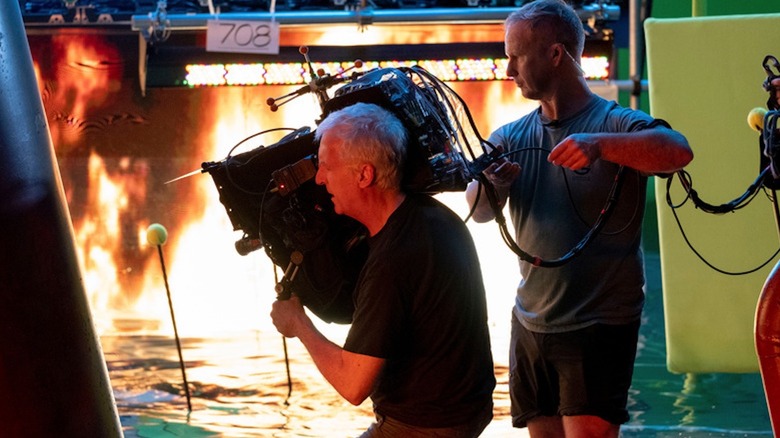 James Cameron operates a camera in a fiery and watery environment on the set of "Avatar: The Way of Water"