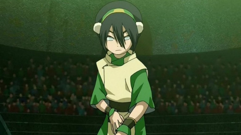 Voice actor Michaela Jill Murphy as Toph standing in the middle of an arena in the original Avatar: The Last Airbender