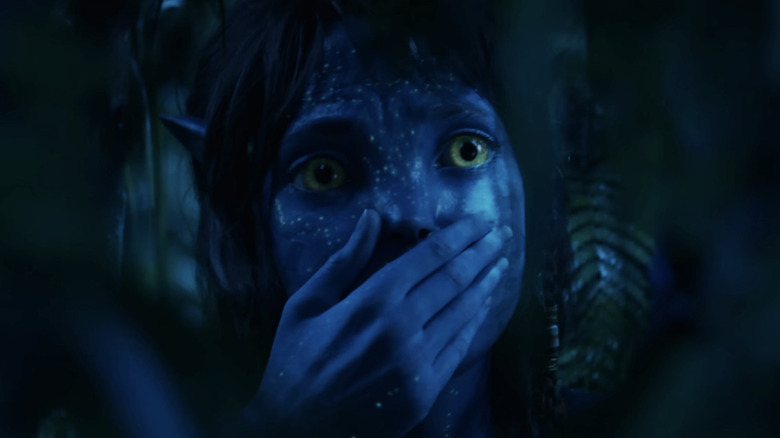 Kiri holds her hand over her mouth in the jungle in Avatar: Fire and Ash