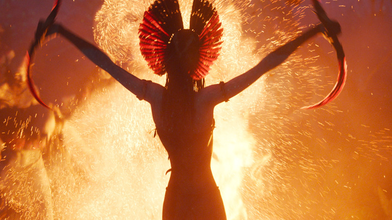 Oonah Chaplin as Varang standing in front of a fire in Avatar: Fire and Ash