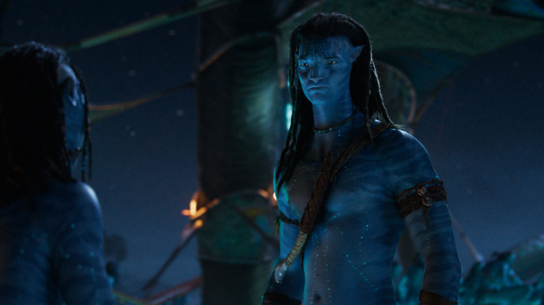 Sam Worthington as Jake Sully standing opposite Britain Dalton as Lo'ak at night in Avatar: Fire & Ash
