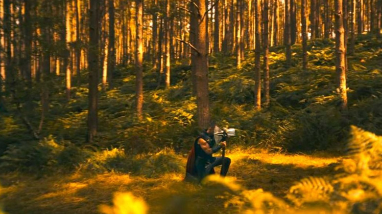 Thor kneels in a wood while holding Stormbreaker in an Avengers: Doomsday teaser