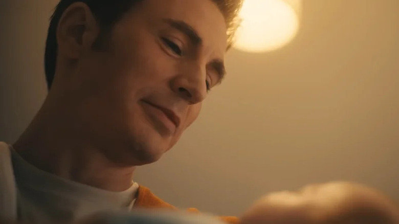 Chris Evans' Steve Rogers looks down as he holds a baby in the Avengers Doomsday trailer