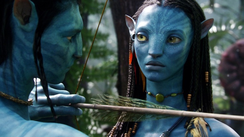 Neytiri teaching Jake Sully how to shoot a bow and arrow in Avatar
