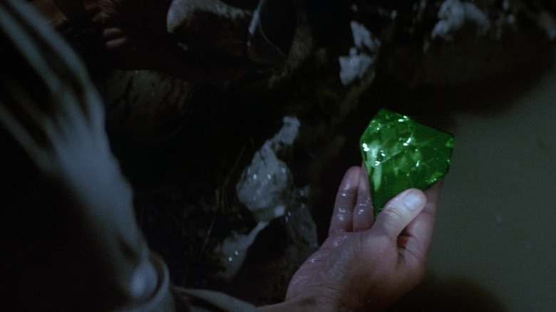 Michael Douglas as Jack holding a green emerald in Romancing the Stone