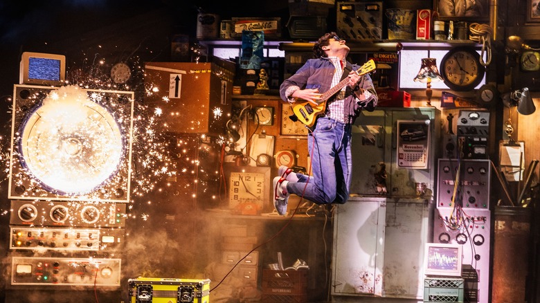 Marty McFly (Casey Likes) leaping with a guitar in Back to the Future: The Musical
