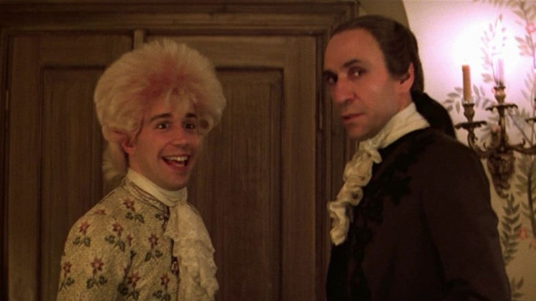 Tom Hulce as Wolfgang Amadeus Mozart and F. Murray Abraham as Antonio Salieri standing in front of each other and looking to their side in Amadeus
